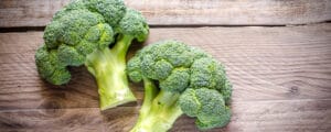 Freshly cut broccoli on a slab of wood